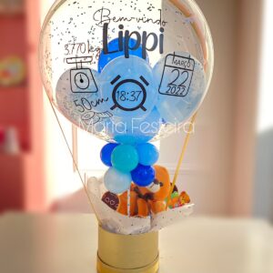 Presente "Bem-Vindo ao Mundo" com balão personalizado, pelúcia fofa e caixa cartonada redonda, ideal para comemorar a chegada de um novo bebê.