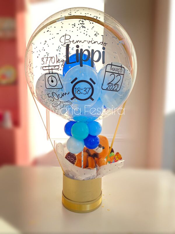 Presente "Bem-Vindo ao Mundo" com balão personalizado, pelúcia fofa e caixa cartonada redonda, ideal para comemorar a chegada de um novo bebê.