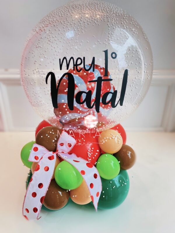 Balão transparente com confetes e glitter, personalizado com balão de doce de Natal e base de mini balões coloridos para decoração natalina.