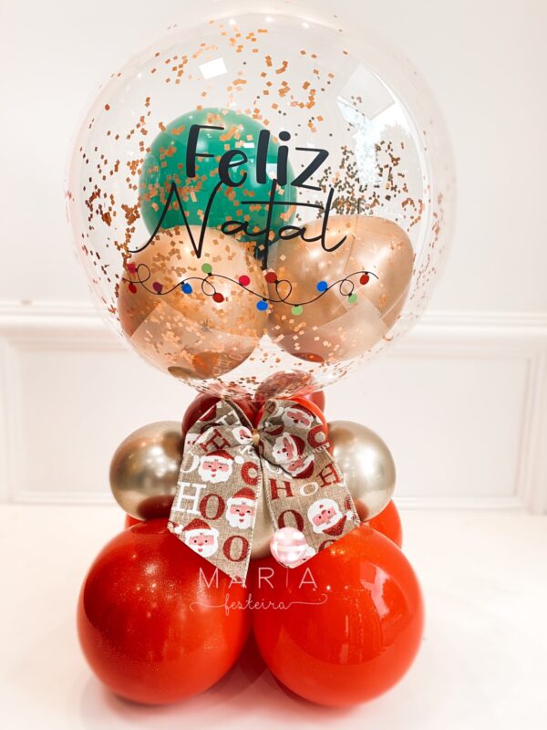 Balão transparente personalizado com efeito de pisca-pisca e escrita natalina, glitter, confetes e base de apoio em balões, ideal para decoração de Natal.