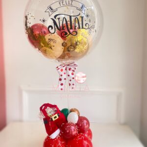 Bolha de Natal Encantado personalizada com glitter, confetes e balões, com base decorada com neve e calça do Papai Noel."