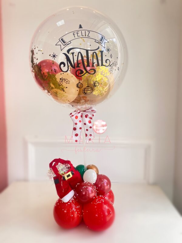 Bolha de Natal Encantado personalizada com glitter, confetes e balões, com base decorada com neve e calça do Papai Noel."