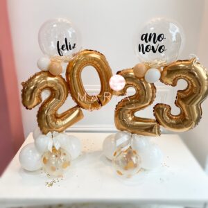 Kit Noite da Virada com balões metálicos personalizados, base decorativa e laço em cetim para festas de Ano Novo.