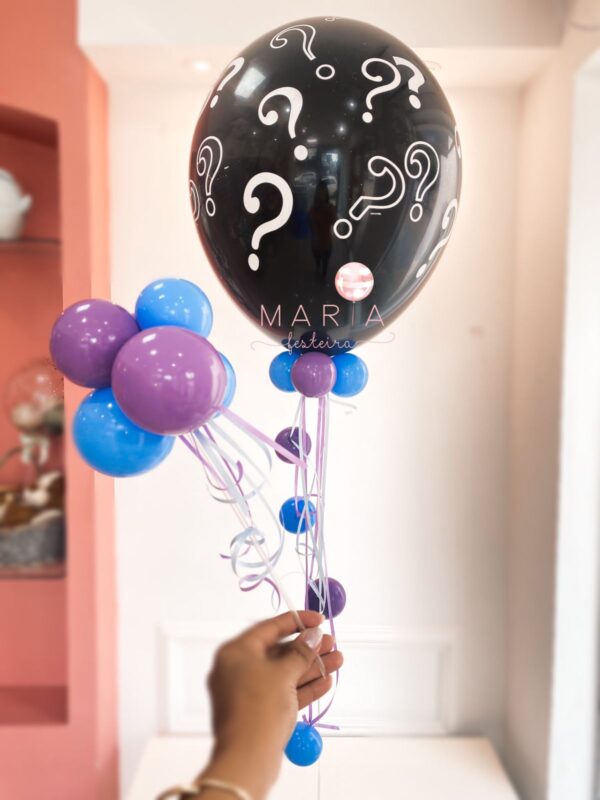 Balão preto com interrogações brancas, recheado com mini balões internos coloridos para chá revelação, acompanhado de pesinho decorativo e fitas.