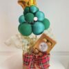 Presente de Natal com Mini Árvore de Balões, chocolates e acabamento em fitas decorativas.