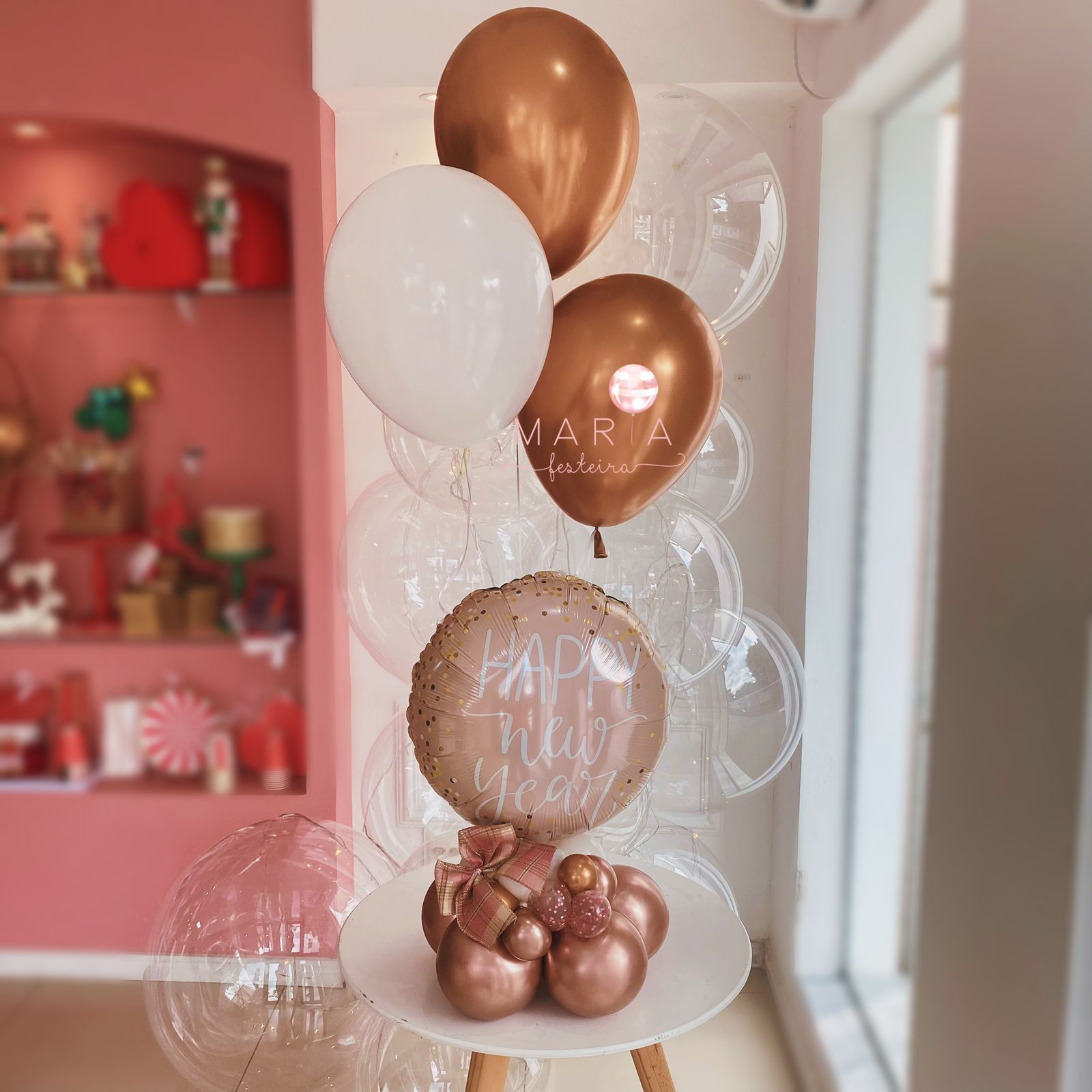 Bouquet de balões Feliz Ano Novo com balão foil personalizado, base desconstruída em rose gold e balões de látex com gás hélio. Decoração elegante para festas de Réveillon.