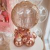 Arranjo de mesa Feliz Ano Novo com balão personalizado em folha de ouro rosa, base de balões desconstruídos e laço decorativo especial