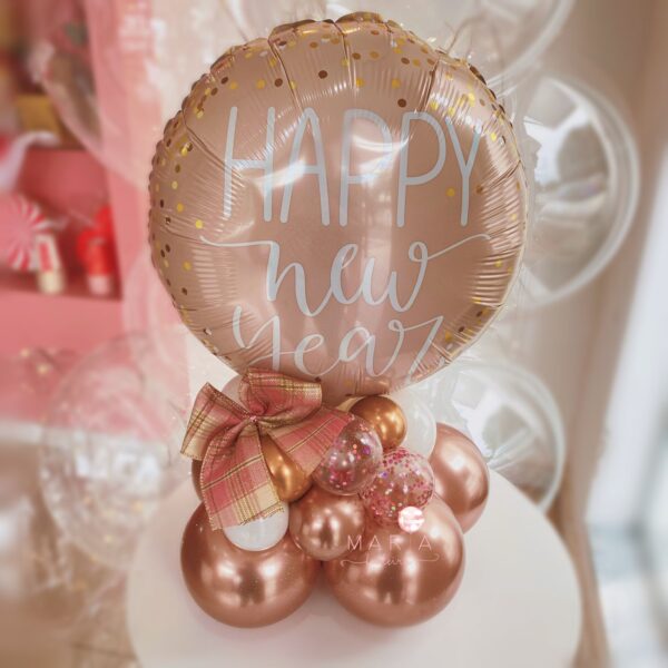 Arranjo de mesa Feliz Ano Novo com balão personalizado em folha de ouro rosa, base de balões desconstruídos e laço decorativo especial