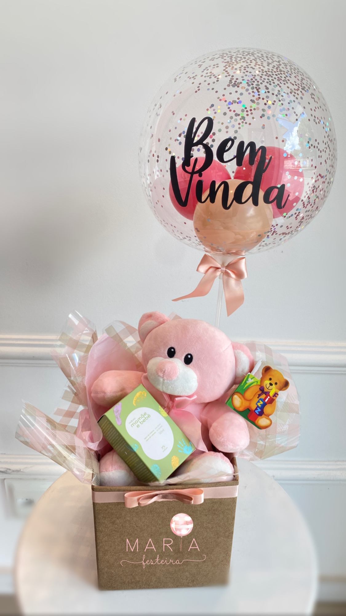 Presente de maternidade com ursinho rosa, balão confete "Bem Vinda" e produtos Natura Mamãe e Bebê, ideal para celebrar a chegada de um bebê menina.