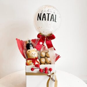 Cesta natalina com vinho, chocolates Teddy Lindt e Ferrero Rocher, mini bubble personalizada e decoração elegante. Presente sofisticado para o Natal.