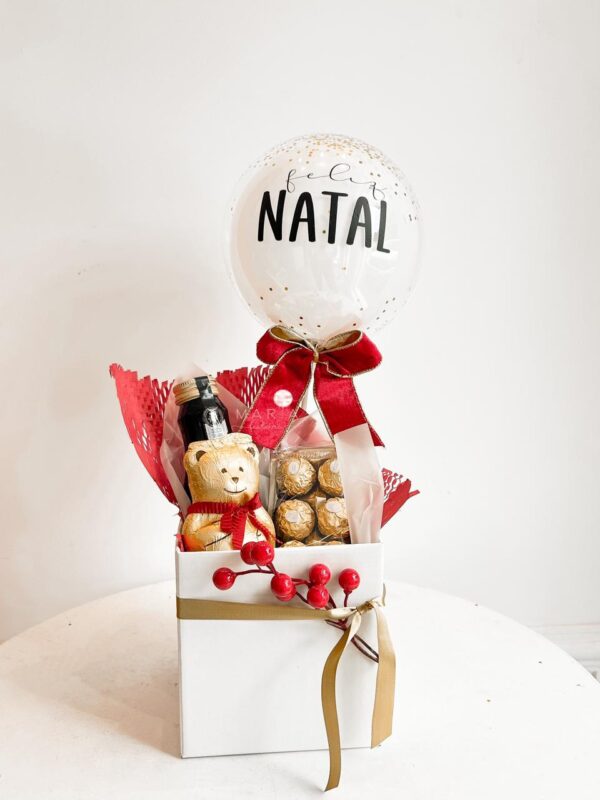 Cesta natalina com vinho, chocolates Teddy Lindt e Ferrero Rocher, mini bubble personalizada e decoração elegante. Presente sofisticado para o Natal.